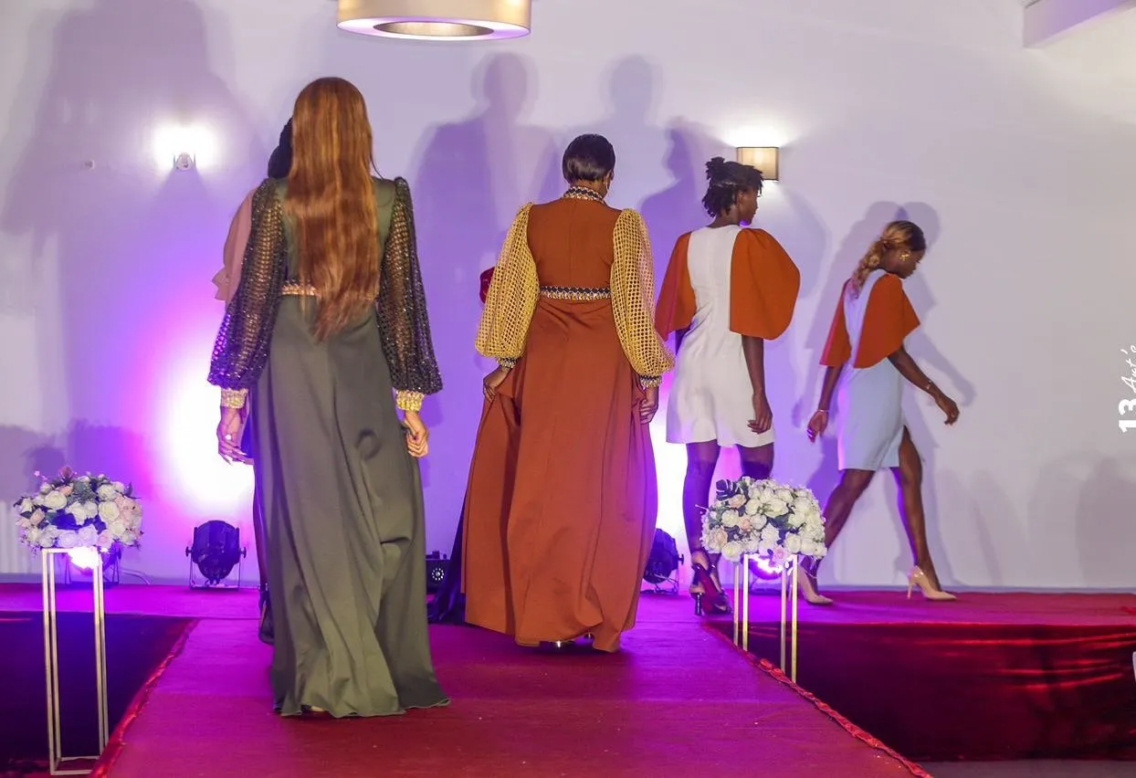 Défilé de mode : mannequins sur podium éclairé, tenues de l’atelier de confection