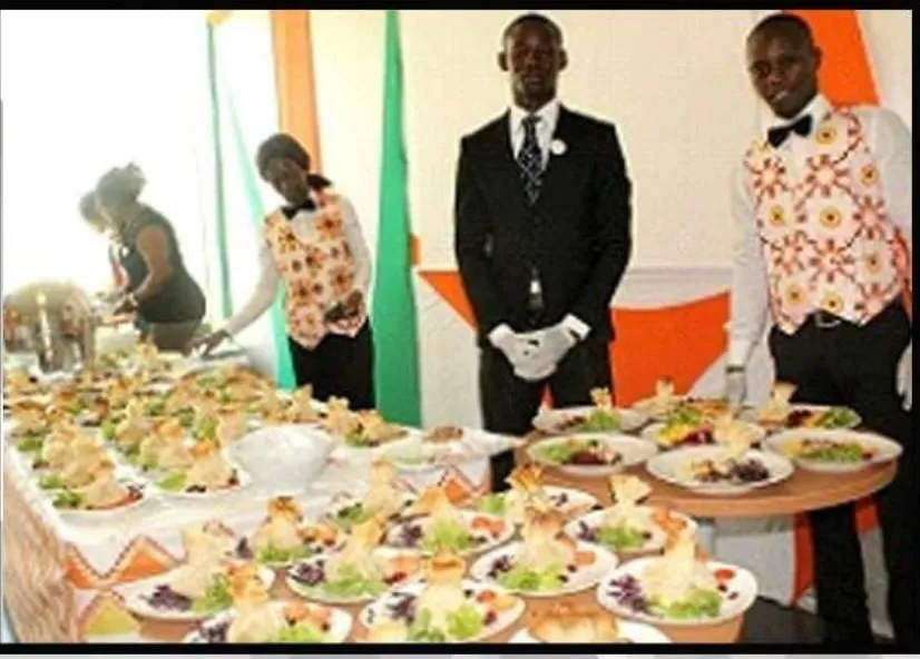 Buffet de réception dressé, pièces cocktail alignées, personnel de service en tenue